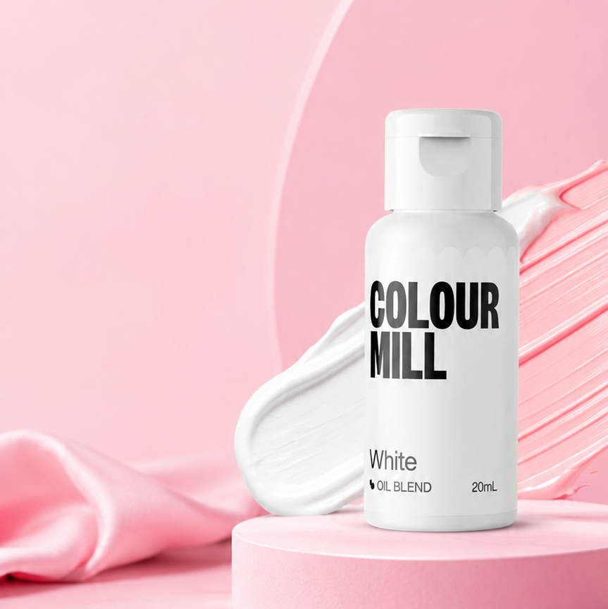 A 20mL bottle of Colour Mill White Hair Color on a pink pedestal with a smear of white cream in the background, set against a pink backdrop with a pink ribbon.